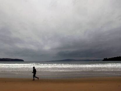 Un hombre hace deporte en la playa Grande del concello coruñés de Miño.
