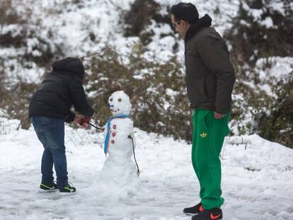 Un padre y su hijo hacen ayer un muñeco de nieve en la carretera A-397 a la altura del desvío de Juzcar en Marbella (Málaga).