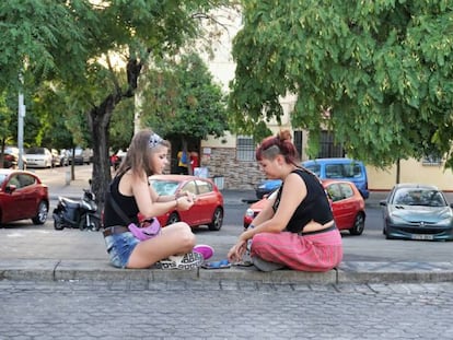 Sandra Rodríguez charla con su amiga en una plaza del barrio sevillano de Los Pajaritos.