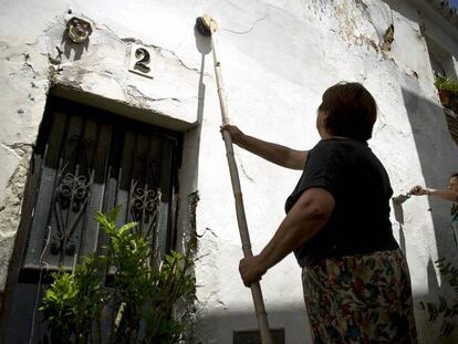 Vecinas de la localidad gaditana de Medina Sidonia pitan con cal las fachadas de sus viviendas.