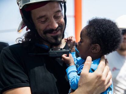 Un rescatador de SOS Méditerranée con un bebé.