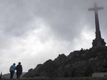 Dos turistas, este martes, ante la cruz del Valle de los Caídos.