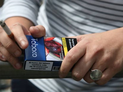 Un fumador, con un paquete de tabaco en la mano.