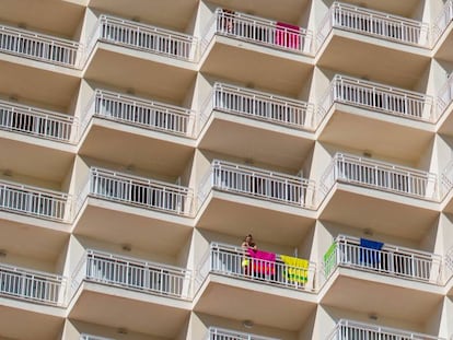 Un turista se asoma al balcón de un bloque de apartamentos de Magaluf, Mallorca.