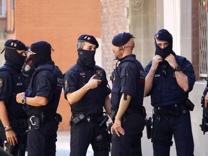 Agentes de los Mossos d'Esquadra ante el número 6 de la calle del Garraf de Cornellà donde vivía el hombre abatido a tiros este lunes.