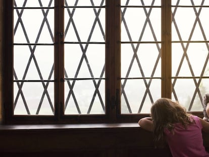 Una niña espera junto a una ventana / En vídeo, unos padres adoptivos devuelven a su hija (ATLAS)