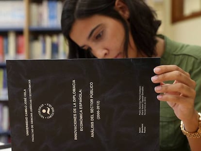 Una mujer lee un ejemplar de la tesis doctoral de Pedro Sánchez que se encuentra en la Universidad Camilo José Cela. ULY MARTIN.