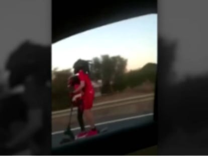 Un hombre y un menor conducen un patinete eléctrico en la autovía V-23, a la altura de la localidad de Sagunto.