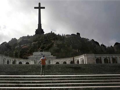 Un turista observa la gran cruz de 130 metros en el Valle de los Caídos. En vídeo, declaraciones del eurodiputado de Podemos Miguel Urbán.