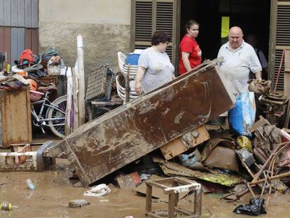 Vecinos de Sant Llorenc des Cardassar limpian su vivienda tras el paso del torrento que ha asolado la localidad.