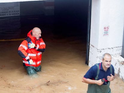 Dos bomberos, en uno de los garajes inundados en Alcoceber (Castellón).