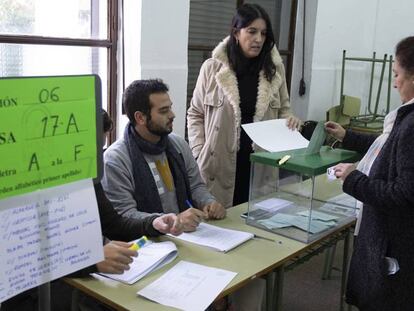 Una mujer vota en Sevilla. En vídeo, la participación en las elecciones andaluzas cae cinco puntos hasta las 18.00 horas.