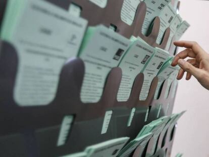 Una votante escoge la papeleta para emitir su voto, este domingo en Sanlúcar de Barrameda (Cádiz). En vídeo, Juan Marín ejerce su derecho al voto en la biblioteca municipal de Sanlúcar.