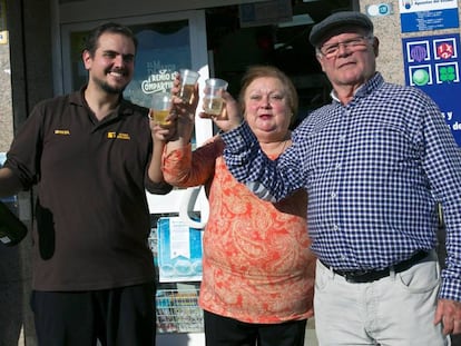 José Delgado (derecha), un frutero jubilado agraciado con siete décimos del Gordo, este sábado en la administración de Lotería de Benajarafe donde compró los décimos.