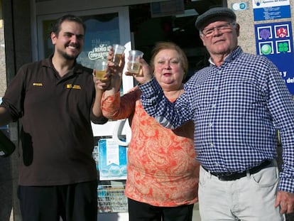 José Delgado (derecha), un frutero jubilado agraciado con siete décimos del Gordo, este sábado en la administración de Lotería de Benajarafe donde compró los décimos.