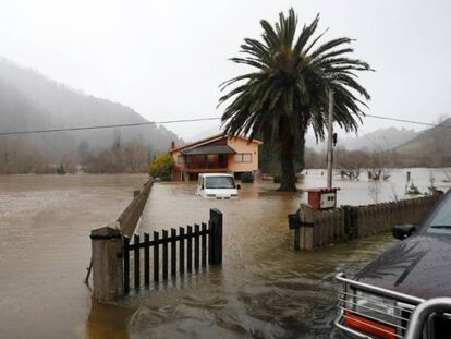 Vista del río Sella, en Asturias, desbordado a su paso por Santianes (Arriondas), este jueves. En vídeo, cuatro muertos por el temporal.