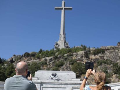 Dos visitantes hacen fotos en el Valle de los Caídos. En vídeo, Los Franco tachan de "ilegal" el traslado de Franco a El Pardo.