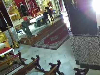 Las dos mujeres detenidas, en la iglesia de la parroquia de San Julián de Sevilla. En vídeo, las arrestadas merodean por el altar.
