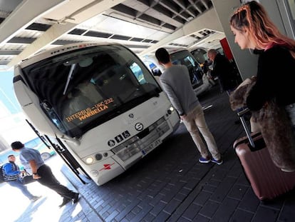 Algunas personas con equipaje en la estación sur de autobuses de Madrid.