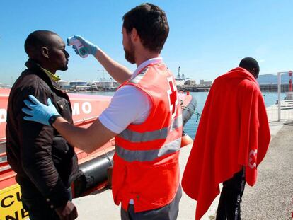 Un enfermero de Cruz Roja toma la temperatura a un inmigrante llegado en patera a Algeciras. En vídeo, el pasado viernes empezó la campaña electoral más reñida.