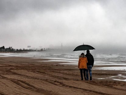 Dos personas caminan este viernes por la playa de la Malvarrosa de Valencia.