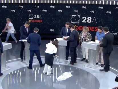 Los candidatos se preparan momentos antes del debate mientras dos señoras de la limpieza abrillantan el suelo. En vídeo, los candidatos hablan sobre las mujeres.