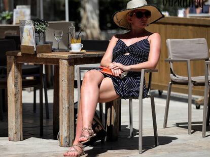 Una mujer toma un café este viernes en la céntrica plaza de la Virgen de Valencia.