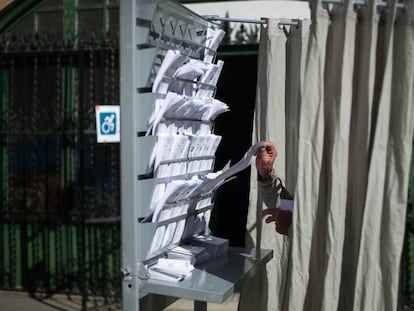 Un ciudadano escoge su papeleta en una cabina de votación de la escuela Infant Jesus, en Barcelona.