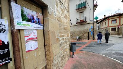 Dos vecinos pasan junto al cartel de EH Bildu en el que agradecen a los vecinos la victoria electoral. En vídeo, declaraciones del candidato a la alcaldía del pueblo por EH Bildu, Pablo Ortiz de Latierro.