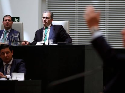 El secretario general de Vox, Javier Ortega Smith (al fondo), observa al popular José Luis Martínez Almeida, investido este sábado alcalde de Madrid. En vídeo, primeras palabras de Ortega Smith como portavoz de Vox en el Ayuntamiento de la ciudad.