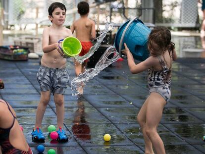 Varios niños juegan con agua en el nuevo espacio del parque Joan Miró, en Barcelona, este martes. En vídeo, llega la primera ola de calor.