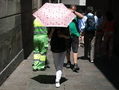 Varias personas pasean, con las altas temperaturas, por el centro de Barcelona. En vídeo, comienza la ola de calor con máximas de 39 grados en Zaragoza y Pamplona.