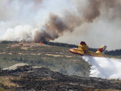 Un hidroavión arroja agua en la zona afectada por los incendios este martes. En vídeo, el viento dificulta la extinción del incendio de La Granja.