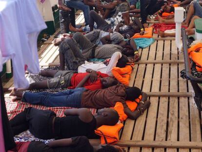 Los rescatados por el 'Open Arms' descansan en la cubierta del buque. En vídeo, los inmigrantes a bordo del barco Open Arms en el Mediterráneo.