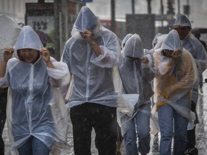 Varias personas se protegen ayer de las intensas precipitaciones en Barcelona. En vídeo, las tormentas que amenazan a la ciudad condal.