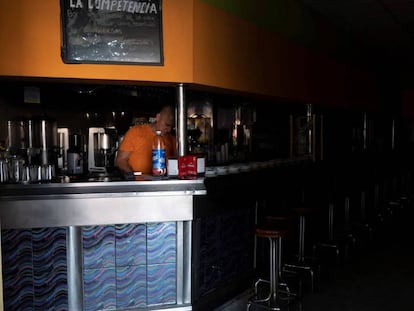 Un empleado de una cafetería de Santa Cruz de Tenerife intenta trabajar a oscuras. En vídeo, el Gobierno canario anuncia sanciones contra los responsables del apagón.