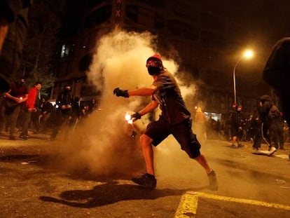 Un manifestante lanza un bote de humo durante los disturbios en Barcelona de este viernes. En vídeo, quinta jornada de disturbios.