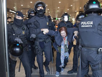 Los Mossos desalojan a una mujer de la estación de Sants de Barcelona, este sábado.