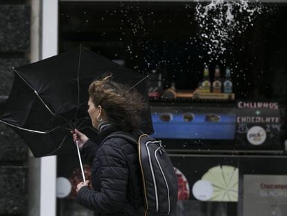 Una racha de viento desbarata el paragüas de una viandante en Sevilla.