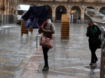 El viento pliega dos paraguas en la plaza Mayor de Salamanca, el jueves.