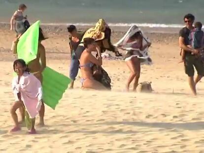 Bañistas afectados por la galerna de este sábado en San Sebastián, donde la temperatura bajó 10 grados.