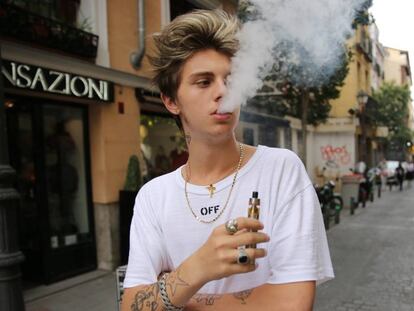 Joven fuma cigarro electrónico en la calle Pelayo de Madrid.