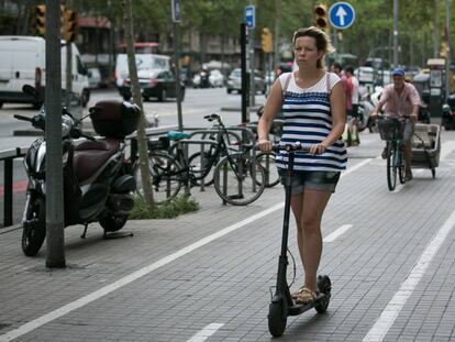 Una mujer en patinete por la ciudad.