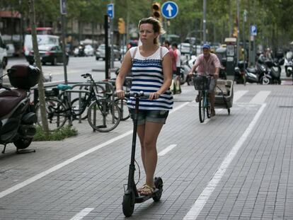 Una mujer en patinete por la ciudad.