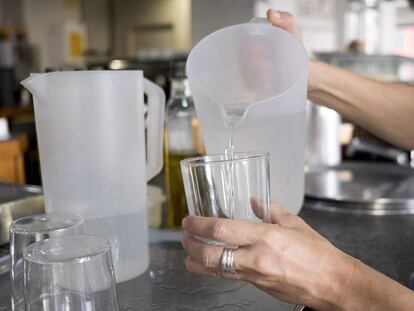 Una mujer echa agua en un vaso en un bar de Sevilla / En vídeo, ¿en qué consiste la iniciativa #PideJarradeAgua? MARIO JARAMILLO, CARLOS MARTÍNEZ