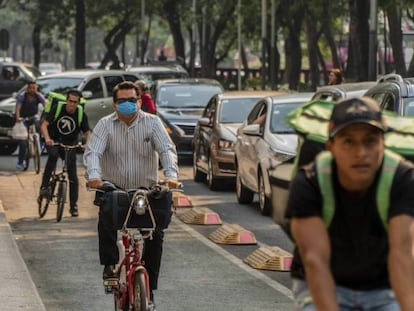 Un ciclista con el rostro cubierto sobre la avenida Reforma. En vídeo, Ciudad de México declara un plan de contingencia por los altos niveles de contaminación.