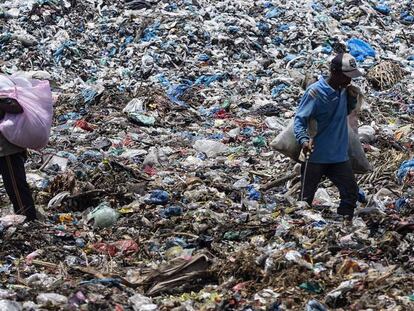 Dos personas rebuscan en la basura en el vertedero de la ciudad de Lhokseumawe (Indonesia). En vídeo, imágenes de una concentración de basura en aguas profundas.