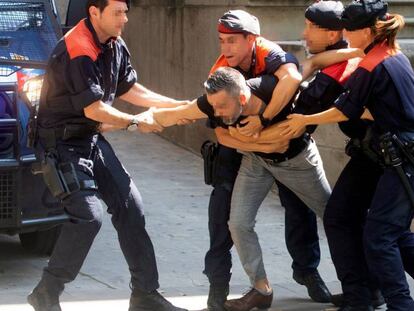 Los Mossos intentan contener a un tío de la víctima de la violación múltiple de Manresa (Barcelona) que intentaba abalanzarse sobre los siete acusados, a las puertas de la Audiencia de Barcelona donde están siendo juzgados.