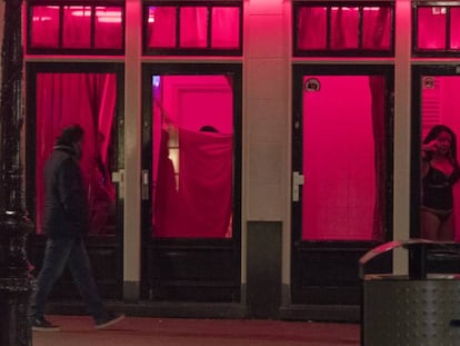 Un hombre pasa frente a un escaparate de prostitutas en el Barrio Rojo de Ámsterdam, en abril de 2017. En vídeo, la alcaldesa de Ámsterdam explica su proyecto.