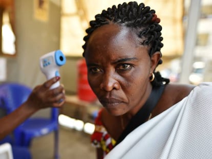 Una sanitaria mide la temperatura de una mujer como parte del dispositivo por el ébola en el hospital general de Goma, en el Congo. En vídeo, la OMS declara emergencia internacional el brote de ébola de la República Democrática del Congo.